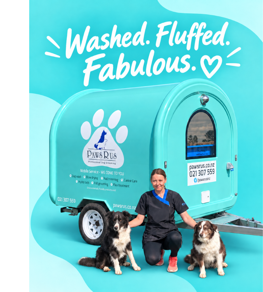 Julie with both dogs in front of the turquoise PawsRus mobile grooming trailer beneath the words Washed. Fluffed. Fabulous.